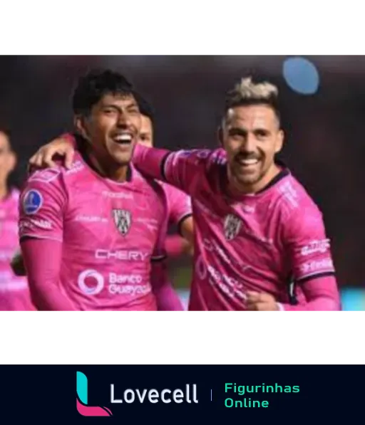 Dois jogadores do Independiente del Valle comemorando com abraços e sorrisos, vestindo uniformes rosa e branco durante partida de futebol