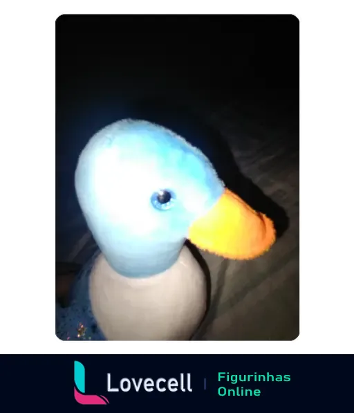 Um pato de brinquedo com corpo branco e azul, bico laranja, em um ambiente escuro com iluminação suave.