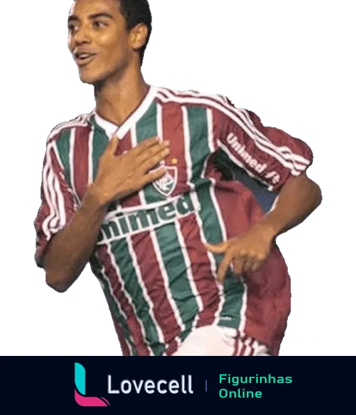 Jogador do Fluminense comemorando gol com mão no coração, vestido com uniforme listrado verde, branco e grená