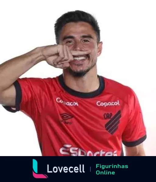 Jogador do Atlético PR comemorando gol, fazendo gesto de ligar telefone, vestindo camisa vermelha com detalhes pretos e logo da Copacol