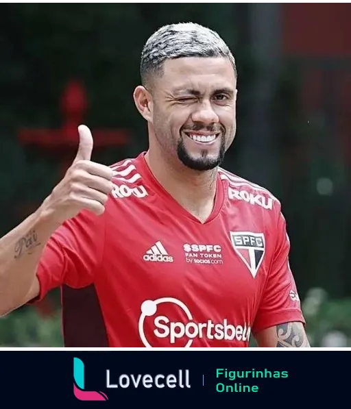 Jogador do São Paulo Futebol Clube sorrindo e fazendo gesto de positivo com uniforme vermelho, patrocínios da Sportsbet e Adidas, em área de treinamento