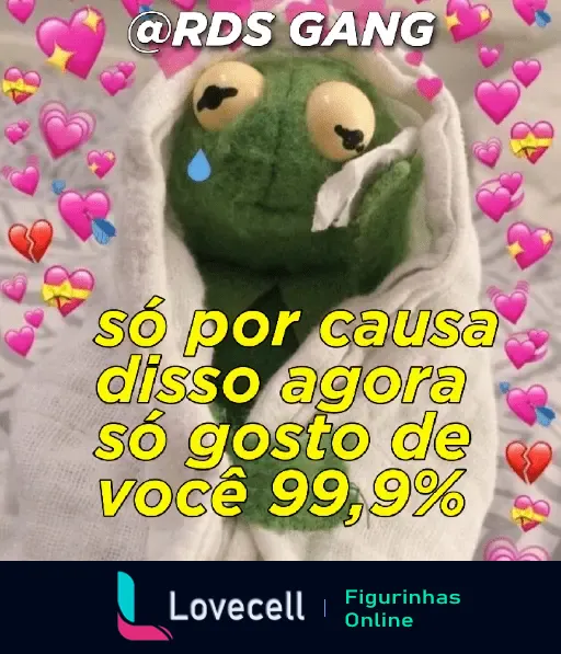 Uma figurinha animada fofa de um sapo verde enrolado em um cobertor com expressão triste. O fundo está cheio de corações coloridos, e o texto diz: 'só por causa disso agora só gosto de você 99,9%'.