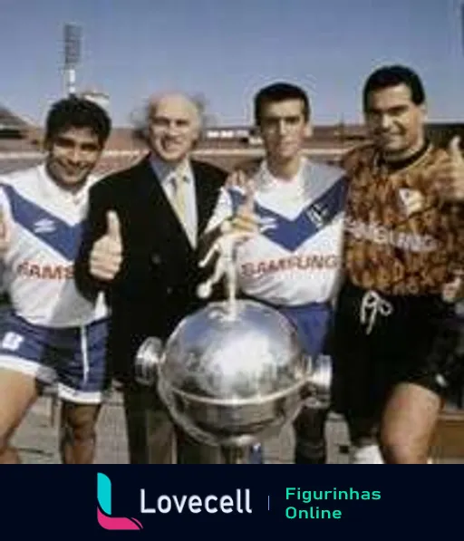 Quatro membros do Vélez Sarsfield, três atletas e um dirigente, posando com a Taça Libertadores. Eles estão vestidos com uniformes esportivos e traje de negócios, sob o sol, com o logotipo da Samsung visível.