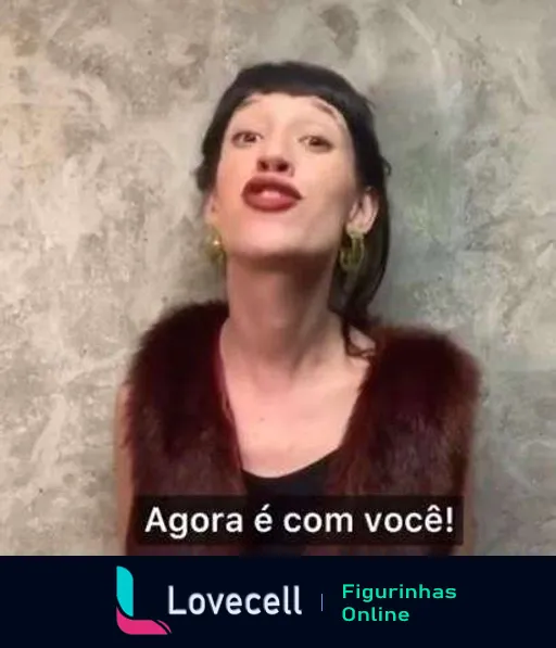 Figurinha de mulher empolgada com expressão teatral e gestos dramáticos, dizendo 'Agora é com você!', usando brincos grandes e casaco de pelos, ideal para momentos de delegar responsabilidades