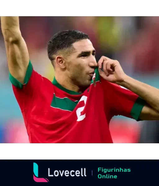 Jogador de futebol marroquino beijando o escudo da camisa verde e vermelha em comemoração de vitória pela seleção nacional