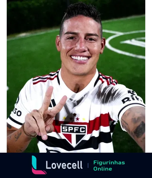 Jogador sorridente do São Paulo Futebol Clube em uniforme oficial fazendo sinal de paz com a mão e exibindo tatuagens no braço esquerdo