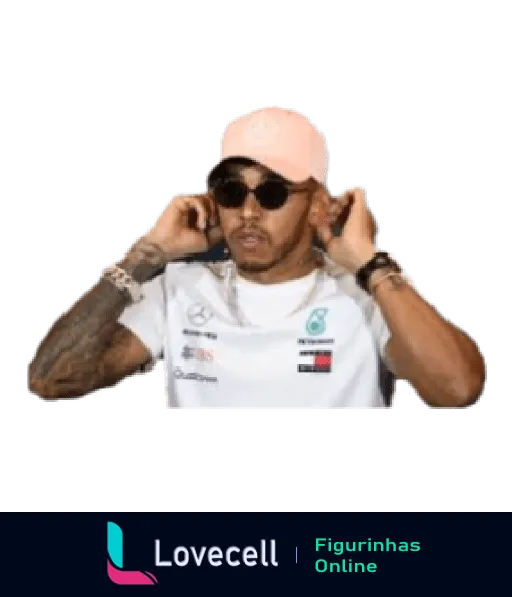 Lewis Hamilton vestido com camiseta branca e boné rosa ajustando óculos escuros, com tatuagens nos braços visíveis, fundo neutro