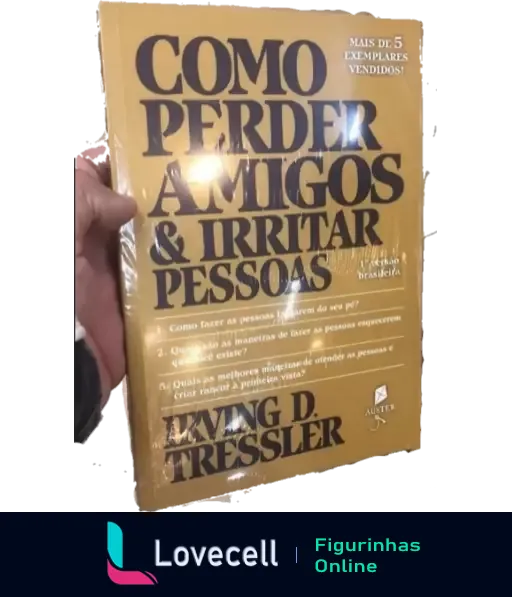 Mão segurando o livro amarelo 'Como Perder Amigos e Irritar Pessoas' de Irving D. Tressler, uma paródia com humor ácido sobre relações sociais