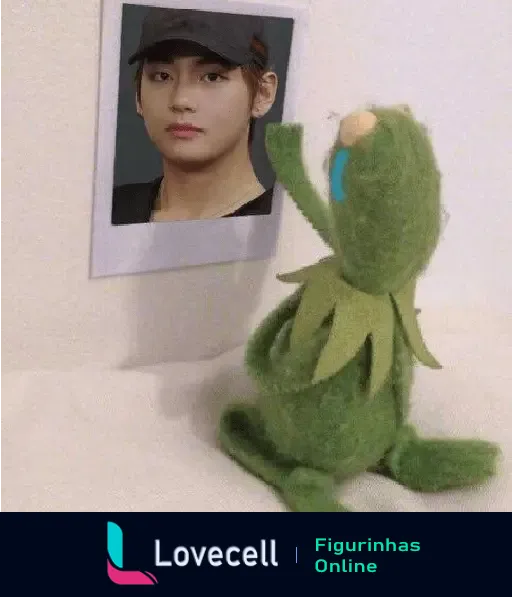 Um sapo de pelúcia chorando e olhando para uma foto de um integrante do BTS em um momento triste.