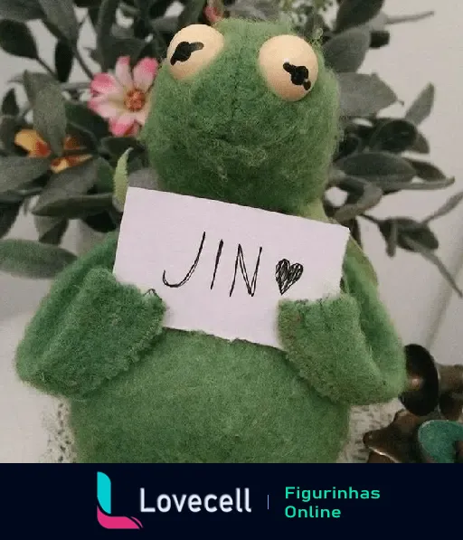 Personagem verde segurando uma placa escrita 'JIN' com um coração, representando um mood triste do BTS. Fundo decorado com flores.