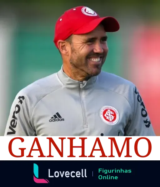 Figurinha de WhatsApp 'Ganhamos' com técnico do Internacional sorrindo, usando agasalho da Adidas e logotipo do Internacional, com palavra 'GANHAMOS' em branco sobre fundo vermelho