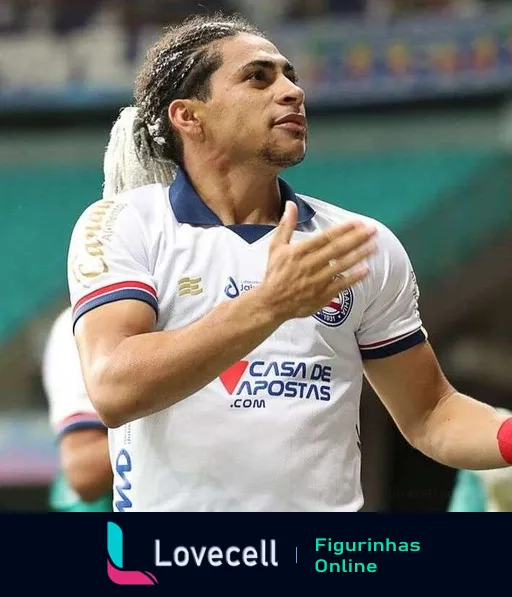 Jogador do Bahia com uniforme branco, azul e vermelho comemorando durante um jogo de futebol