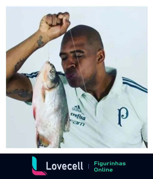 Jogador do Palmeiras segurando um peixe pela boca com expressão divertida, vestindo uniforme branco da Adidas