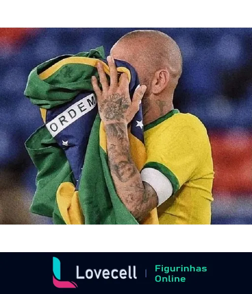 Jogador de futebol brasileiro, careca e tatuado, cobrindo o rosto com a bandeira do Brasil em expressão de emoção e orgulho nacional