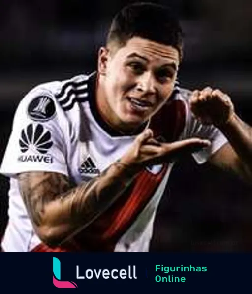 Jogador do River Plate comemorando um gol, sorrindo e fazendo gesto de telefonema, uniforme com logo da Huawei