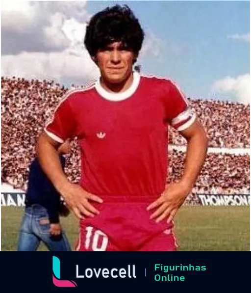 Jogador de futebol com camiseta vermelha número 10 e logotipo da Adidas no campo, estádio cheio ao fundo