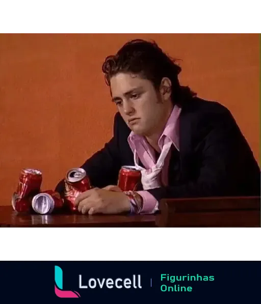 Cena da série RBD mostrando um homem com expressão triste sentado em uma mesa junto a várias latas de refrigerante vazias.