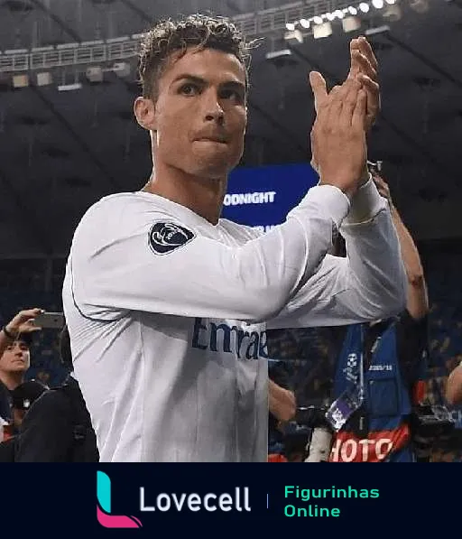 Cristiano Ronaldo vestido com o uniforme do Real Madrid aplaude seriamente num estádio, possivelmente agradecendo a audiência após um jogo.