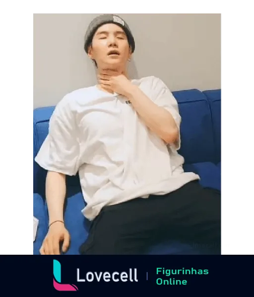 Pessoa usando uma touca cinza e camiseta branca, repousando exausta em um sofá azul com a mão no pescoço. - BTS