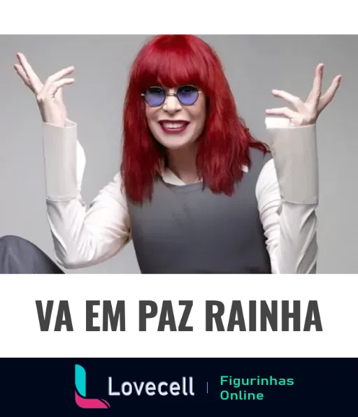 Rita Lee com cabelos vermelhos e óculos azuis fazendo gesto expressivo com as mãos e sorrindo