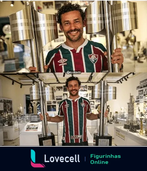 Fred sorrindo e segurando troféus do Fluminense, vestido com a camisa do time, rodeado de memorabilia esportiva