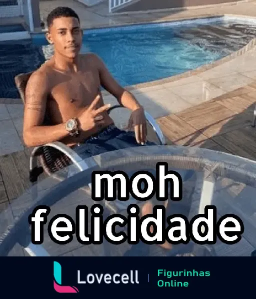 Homem sentado em uma cadeira ao lado de uma piscina, fazendo sinal de paz com a mão e exibindo um sorriso. Texto: 'moh felicidade'.