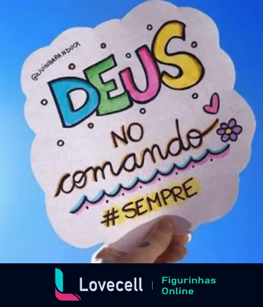 Em um papel recortado com bordas arredondadas, escrito em letras coloridas e decorativas a frase: DEUS no comando #SEMPRE, com desenhos de um coração e flor. Fundo azul claro.