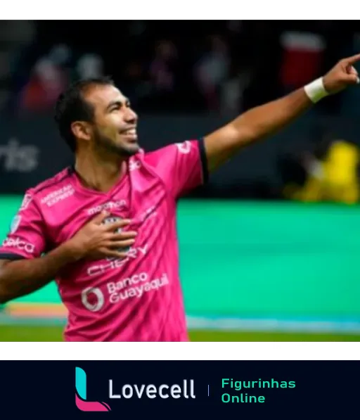 Jogador do Independiente del Valle comemorando com uniforme rosa e apontando para o céu em jogo de futebol