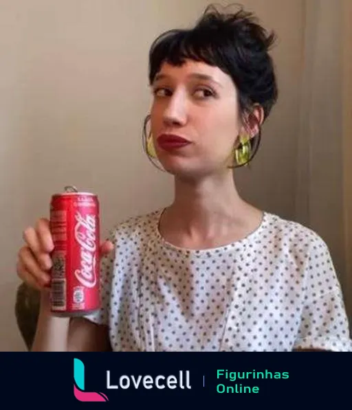 Tina com expressão pensativa e cômica segurando uma lata de Coca-Cola, olhando para o lado, usando brincos grandes e blusa de bolinhas