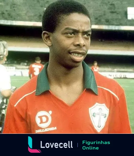 Jogador de futebol da Portuguesa vestido com uniforme vermelho e verde e logo da Della Sera em estádio