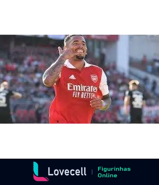 Jogador do Arsenal comemorando com uniforme vermelho, sorrindo e interagindo com fãs ao fundo após marcar um gol