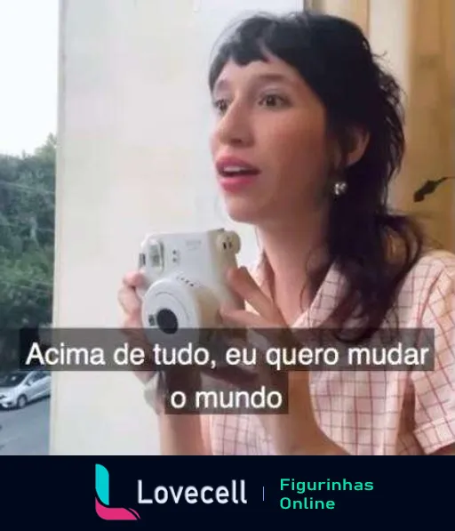 Mulher inspirada segurando câmera instantânea e olhando para o lado com a frase 'Acima de tudo, eu quero mudar o mundo' em uma casa