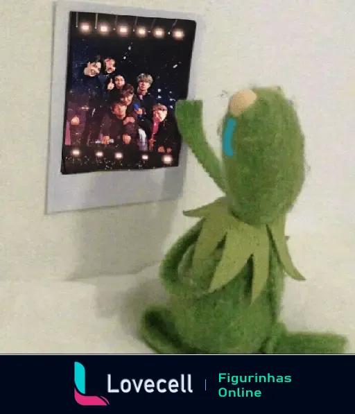 Kermit o sapo chorando ao olhar foto do BTS no papel de parede com luzes ao fundo, representando um mood triste.