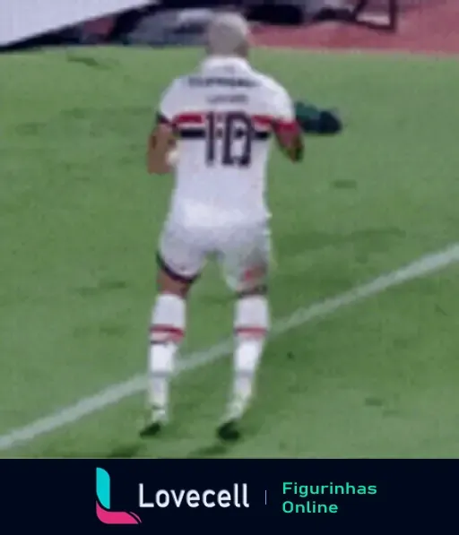 Jogador de futebol ajoelhado, celebrando com os braços levantados em sinal de vitória, usando uniforme branco com detalhes em vermelho.