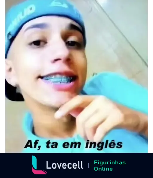 Um jovem sorridente com bonnet azul e sorriso com aparelho, mostrando a mão em gesto, com o texto 'Af, tá em inglês' ao fundo.