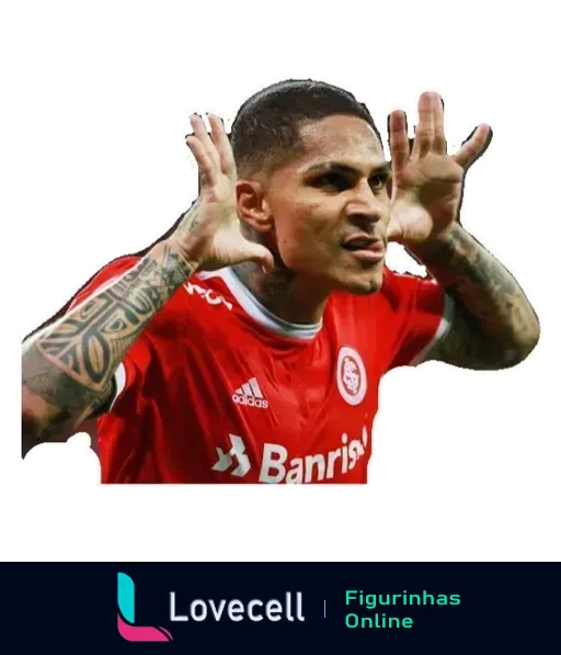 Jogador do Internacional comemorando com uniforme vermelho, logo da Adidas e Banrisul, fazendo gesto com as mãos ao lado da cabeça