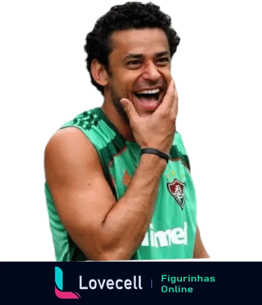 Fred, jogador do Fluminense, rindo durante treino com uniforme verde e detalhes brancos, exibindo cabelos cacheados e sorriso contagioso