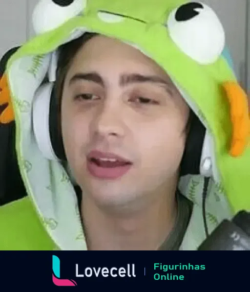 ALANZOKA usando um capuz verde de sapo com capuz e fones de ouvido, aparentemente falando ou jogando online.