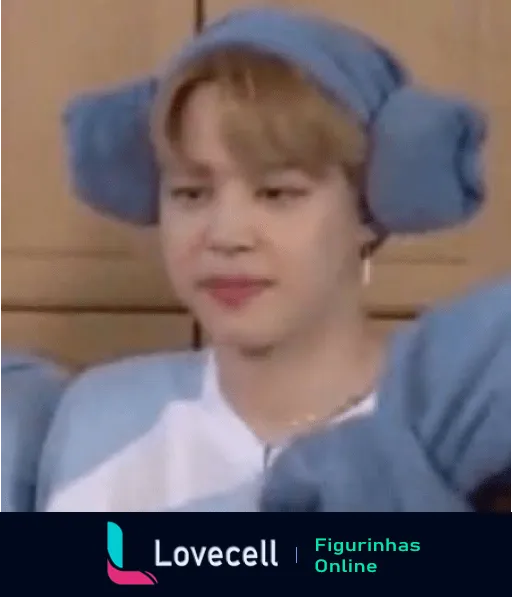 Membro do BTS usando um chapéu de pelúcia azul com orelhas grandes, expressão neutra, fundo amadeirado. Visual adorável e engraçado.