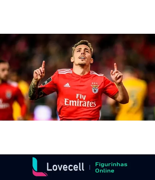 Jogador do Benfica celebrando gol em campo, vestindo uniforme vermelho com logotipo da Fly Emirates, apontando para cima com os dedos