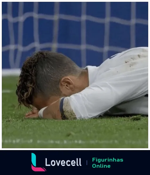 Jogador de futebol decepcionado deitado no gramado sujo de lama, com uniforme branco, expressando tristeza após um momento difícil em partida