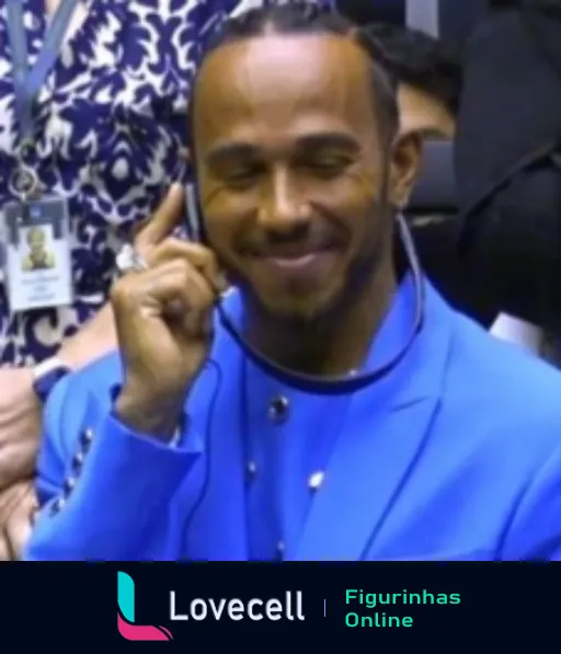 Lewis Hamilton sorridente com blazer azul, dedo indicador levantado, expressando um ponto importante de maneira confiante e descontraída