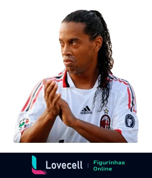 Ronaldinho vestindo a camisa do Milan aplaudindo com expressão séria e cabelos longos visíveis