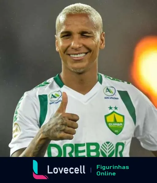 Jogador do Cuiabá com cabelo curto platinado, sorrindo e fazendo sinal de positivo, vestindo camisa branca e verde com patrocínio da Brebort