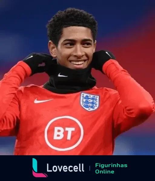 Jogador de futebol Beligol Bellingham, vestindo agasalho da seleção inglesa com as mãos ao redor do pescoço em um clima frio.