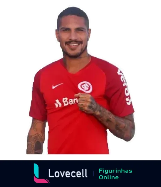 Jogador do Internacional sorridente com uniforme vermelho, tatuagens nos braços e apontando para o logotipo lovecell na camisa