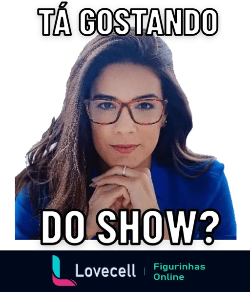 Mulher com óculos e cabelo preso em blazer azul apoiando o queixo nas mãos e perguntando 'Tá gostando do show?'