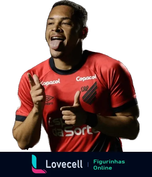 Jogador do Atlético PR comemorando, sorrindo e fazendo sinal de positivo com as mãos, vestido com uniforme vermelho e preto da Umbro