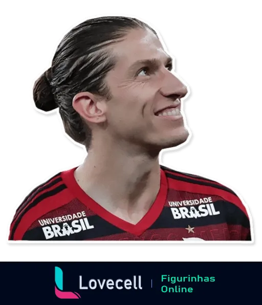 Jogador do Flamengo sorridente com cabelos longos amarrados, vestindo camisa vermelha e preta com logotipos da Universidade Brasil, expressando alegria